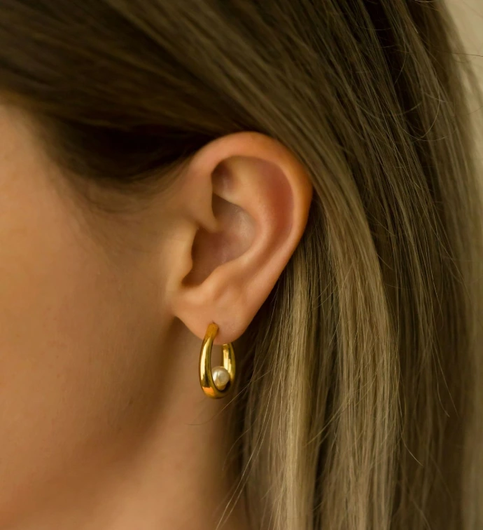 a close up of a person wearing a pair of earrings